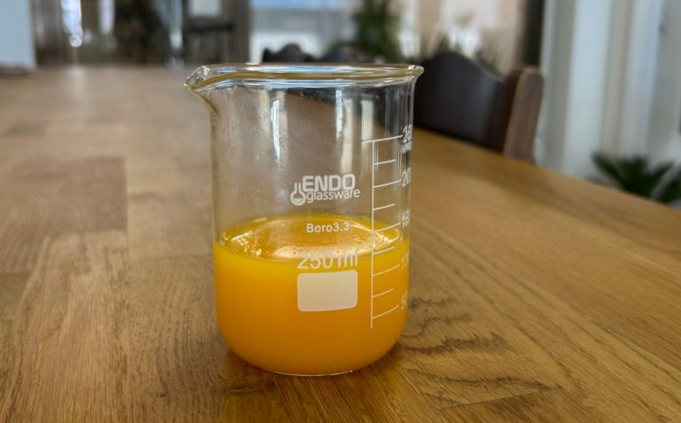 In the photo can see mandarin juice from concentrate manufactured by baor products. In this photo can see the turbidity and color of this juice