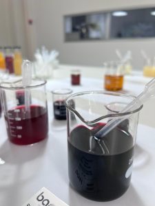 Laboratory analysis of organic aronia concentrate in beakers for quality control.