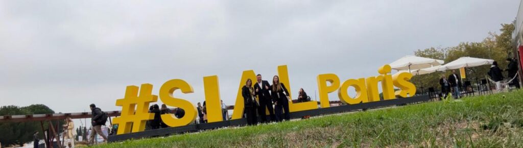 BAOR Products team at SIAL Paris, standing beside the yellow #SIALParis sign.